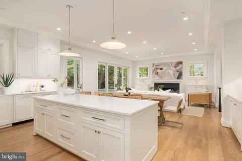 a kitchen with a dining table chairs and white cabinets
