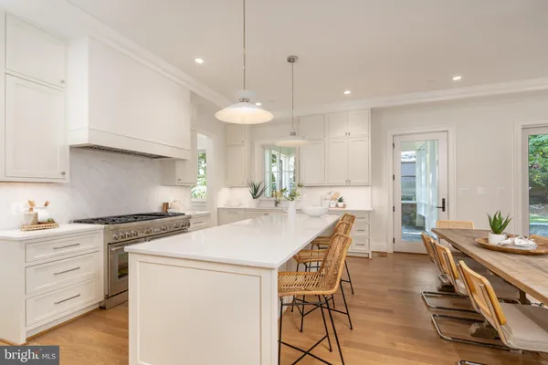 a living room with furniture kitchen and a large window