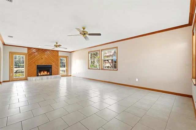 a view of an empty room with a fireplace and a window