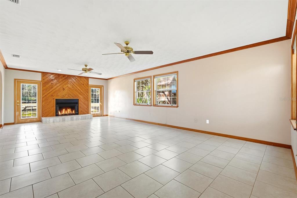 404 Old Haw Creek Road Bunnell, FL 32110 - Photo 14 of 51 a view of an empty room with a fireplace and a window