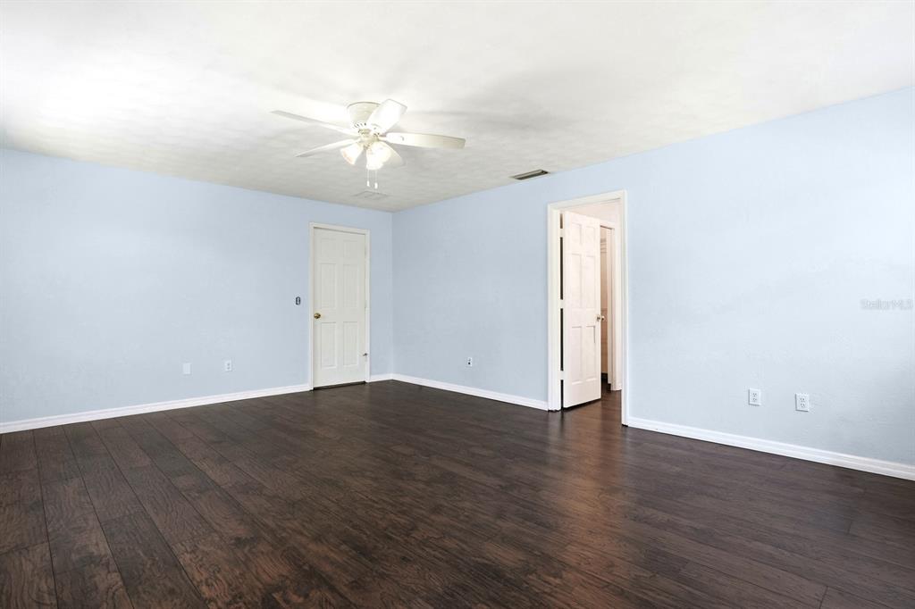 404 Old Haw Creek Road Bunnell, FL 32110 - Photo 23 of 51 an empty room with wooden floor fan and windows