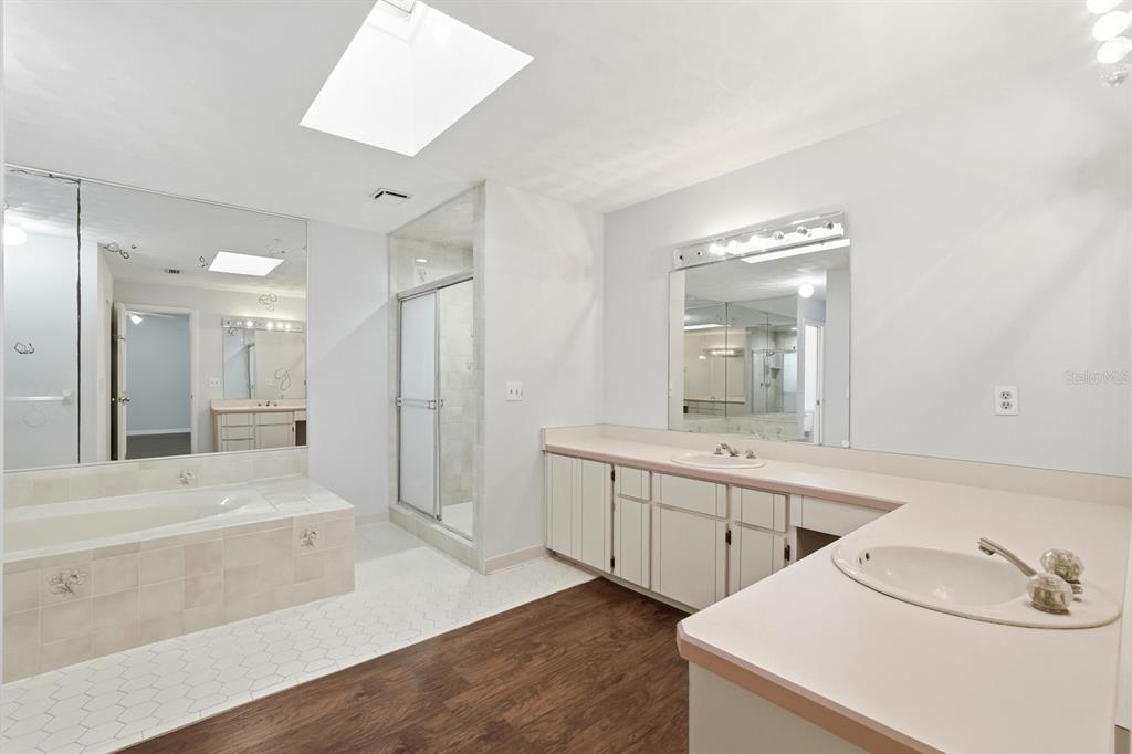 404 Old Haw Creek Road Bunnell, FL 32110 - Photo 24 of 51 a bathroom with a double vanity sink and mirror with bathtub