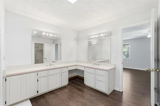a spacious bathroom with a double vanity sink a mirror and a