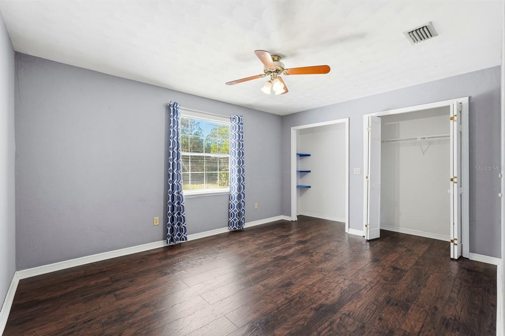 404 Old Haw Creek Road Bunnell, FL 32110 - Photo 27 of 51 an empty room with wooden floor fan and windows