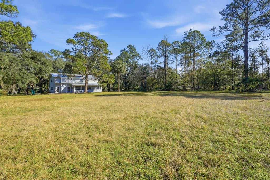 404 Old Haw Creek Road Bunnell, FL 32110 - Photo 42 of 51 a view of a swimming pool with an outdoor seating and a garden