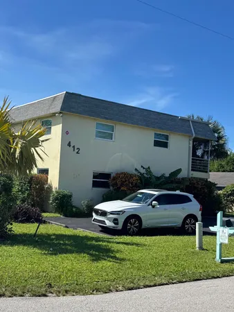 a car parked in front of a house with a big yard