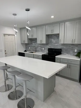 a kitchen with a sink a stove and chairs
