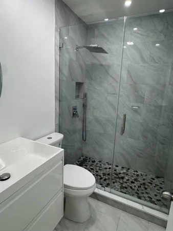 a bathroom with a sink a toilet and shower