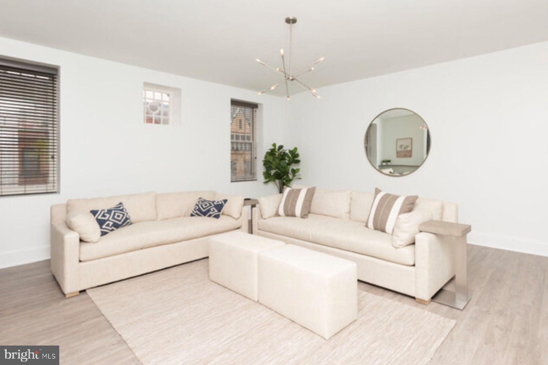 1012 North Calvert Street, Unit 3B Baltimore, MD 21202 - Photo 6 of 9 a living room with furniture a large window and a clock