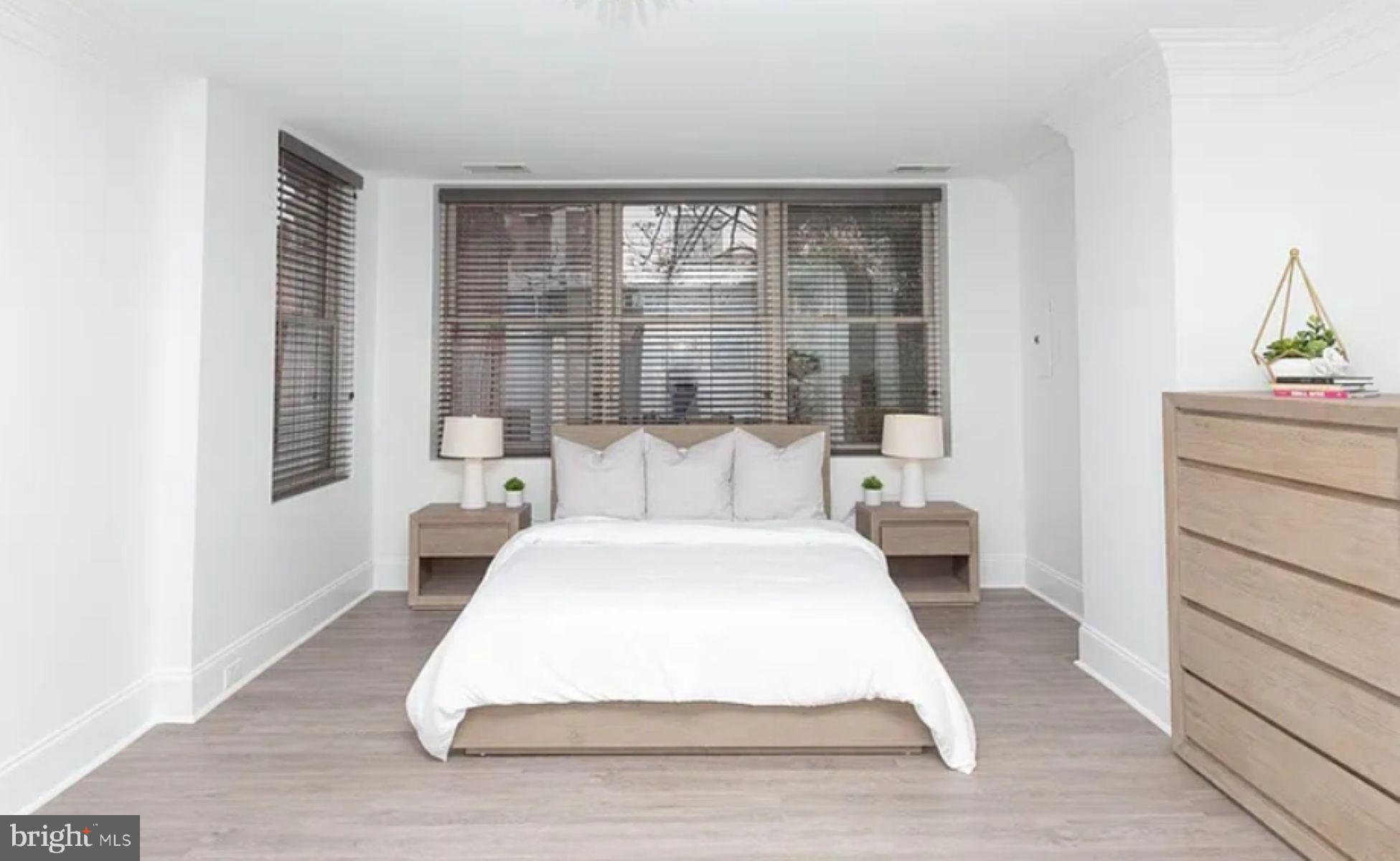 1012 North Calvert Street, Unit 3B Baltimore, MD 21202 - Photo 7 of 9 a large white bed in a bedroom next to a window