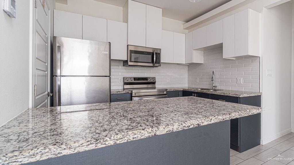 901 East Yuma Avenue, Unit 1902 McAllen, TX 78503 - Photo 3 of 13 a kitchen with a refrigerator and a stove top oven