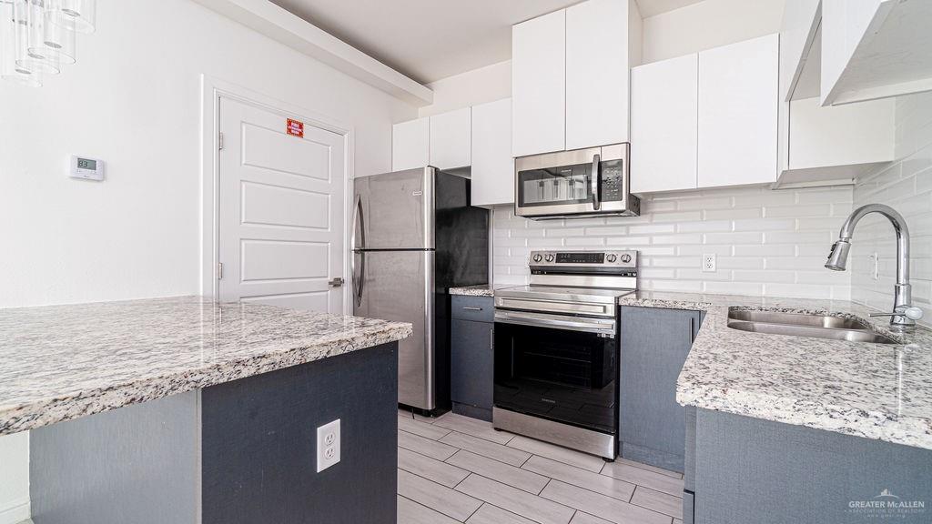 901 East Yuma Avenue, Unit 1902 McAllen, TX 78503 - Photo 4 of 13 a kitchen with stainless steel appliances granite countertop a sink stove and refrigerator