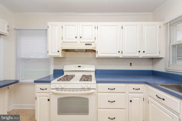 a kitchen with granite countertop white cabinets and white appliances
