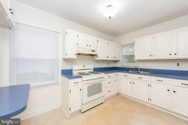 a kitchen with granite countertop white cabinets and white appliances