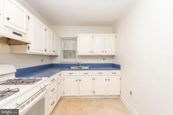 a kitchen with granite countertop white cabinets and stainless steel appliances