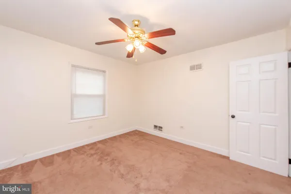 an empty room with closet and a chandelier fan