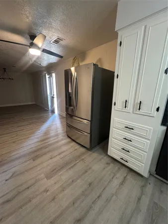 an empty room with wooden floor and white walls