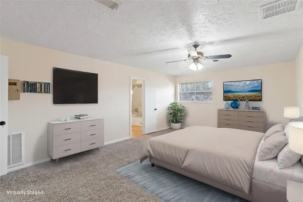 a spacious bedroom with a bed and a flat screen tv