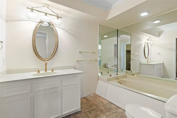 a bathroom with a tub sink and mirror