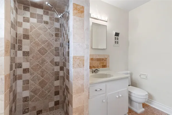 a bathroom with a granite countertop toilet a sink and a mirror