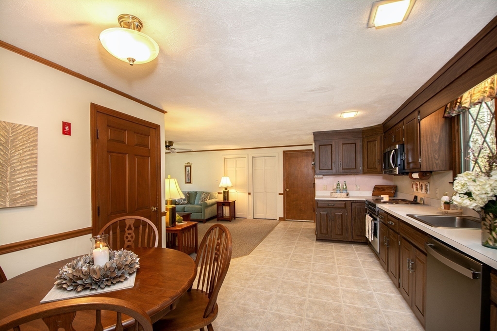 339 School Street Marshfield, MA 02050 - Photo 13 of 40 a large kitchen with stainless steel appliances granite countertop a stove a sink a dining table and chairs