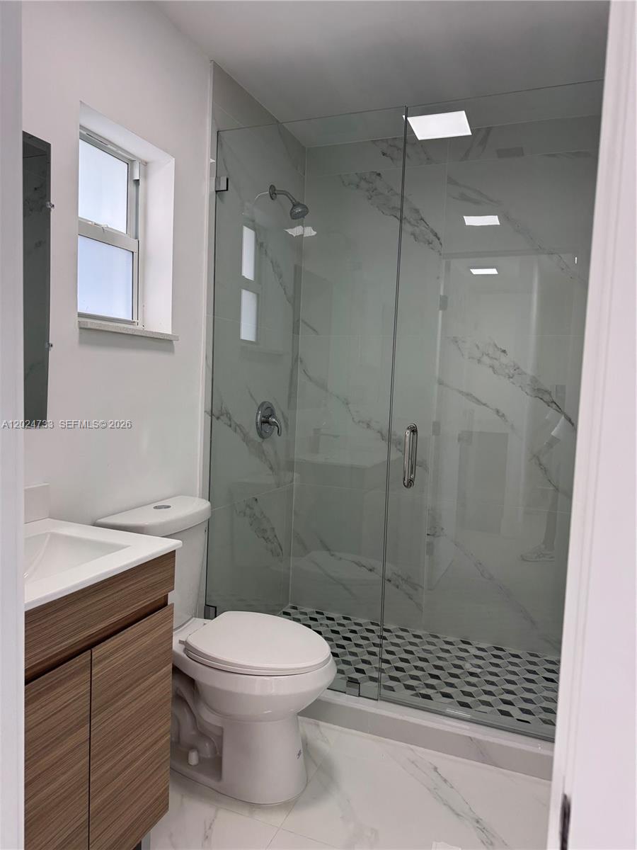 3305 Southwest 28th Street, Unit 3305 Miami, FL 33133 - Photo 15 of 17 a bathroom with a shower a toilet and a sink