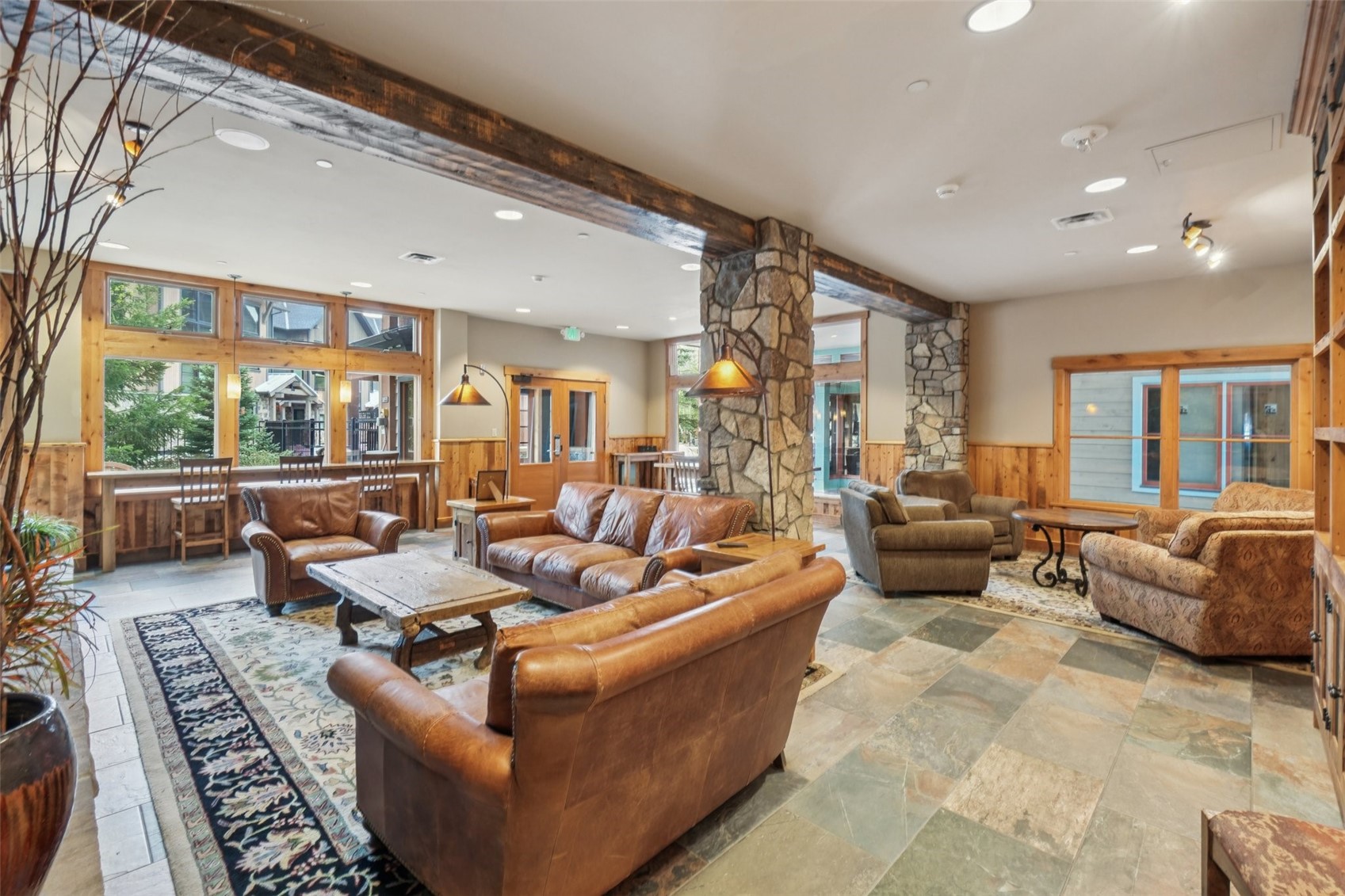 129 River Run Road, Unit 8055 Keystone, CO 80435 - Photo 33 of 50 Living area featuring wainscoting, recessed lighting, stone tile flooring, wooden walls, and beam ceiling