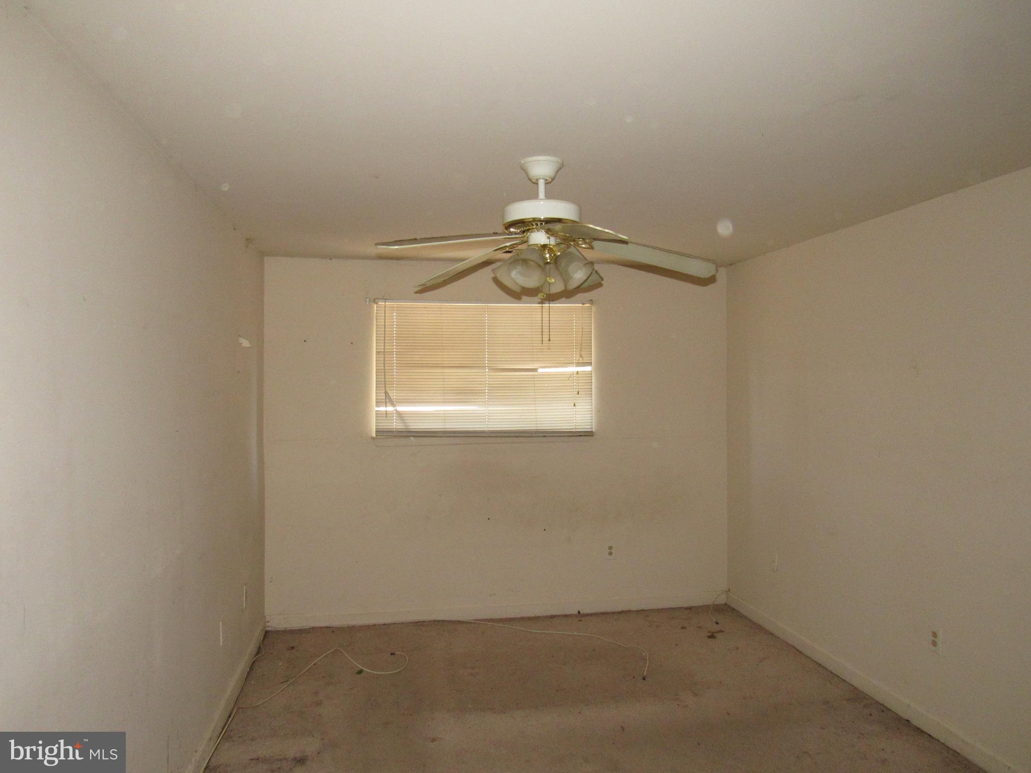 6708 Ridge Road, Unit 102 Baltimore, MD 21237 - Photo 8 of 14 an empty room with a chandelier fan and wooden floor