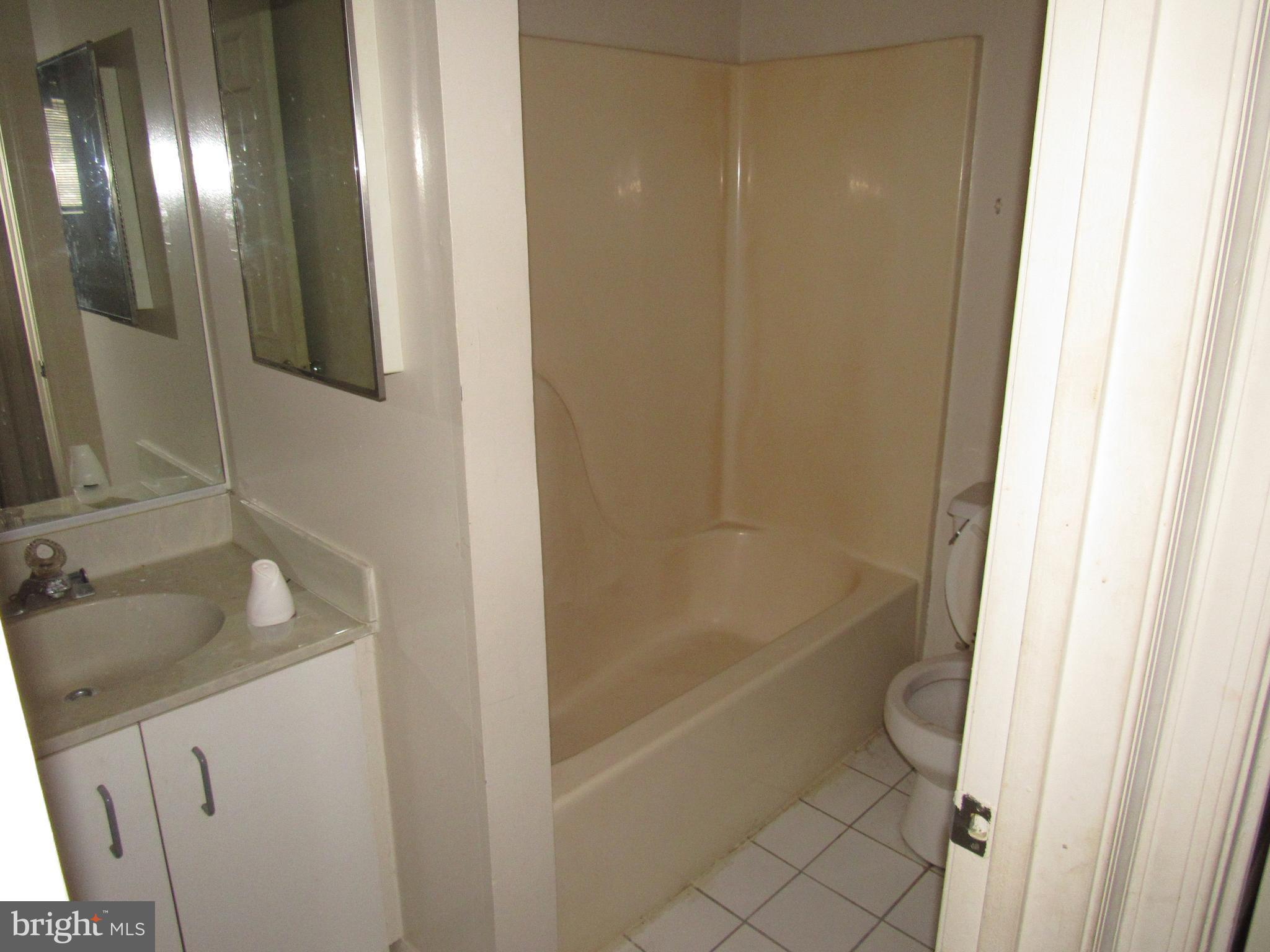 6708 Ridge Road, Unit 102 Baltimore, MD 21237 - Photo 10 of 14 a bathroom with a granite countertop sink toilet and shower