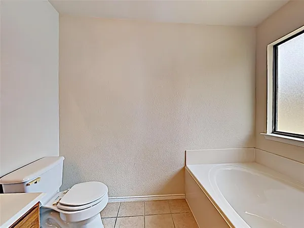 a bathroom with a granite countertop toilet and a bathtub