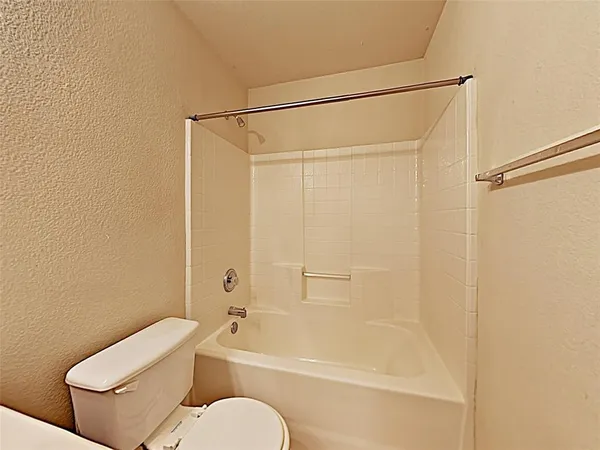 a bathroom with a shower a toilet and a bath tub