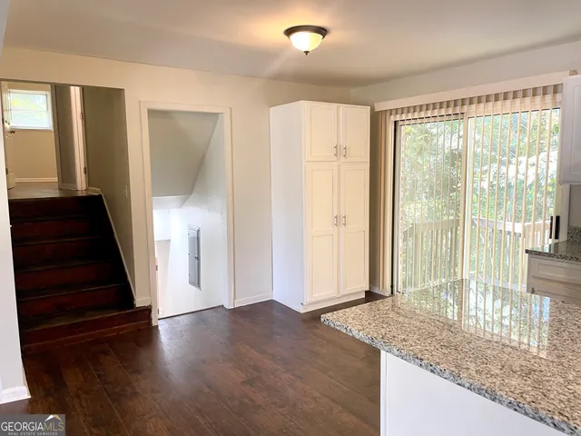 a view of a hallway with wooden floor and staircase