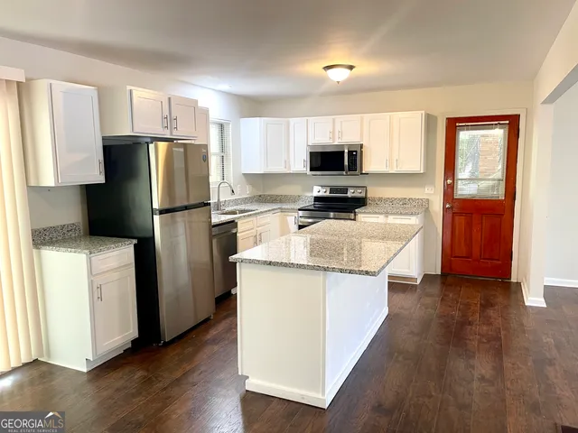 a kitchen with stainless steel appliances a refrigerator stove microwave and sink