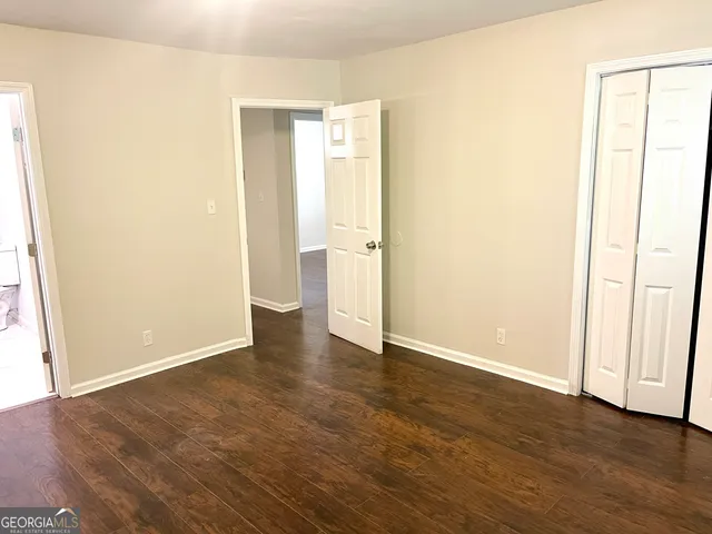 an empty room with wooden floor and closet