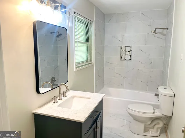 a bathroom with a sink toilet tub and shower