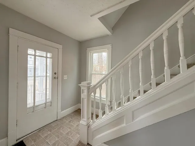 a view of staircase with lots of white walls and a window
