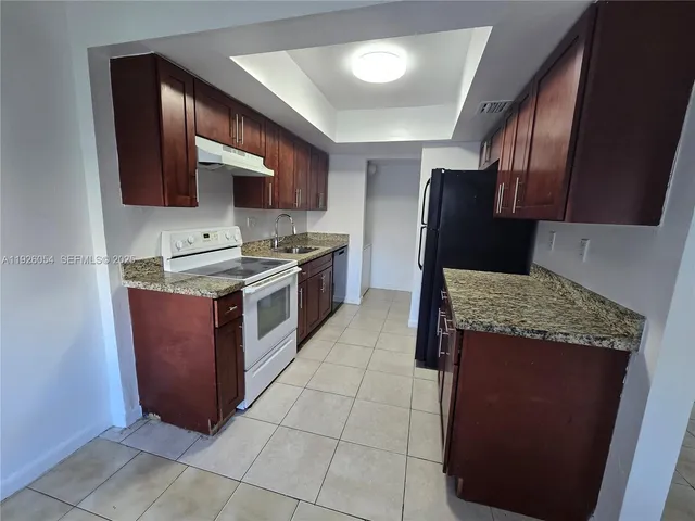 a kitchen with stainless steel appliances granite countertop wooden cabinets a sink and dishwasher