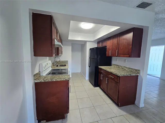 a kitchen with stainless steel appliances granite countertop a stove and a refrigerator