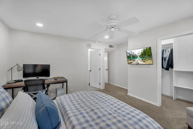 a bedroom with a bed and a flat screen tv