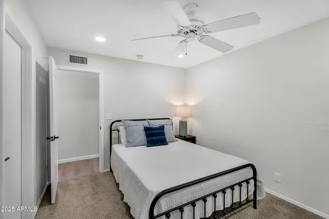 a bedroom with a bed and a ceiling fan