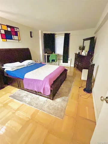 a bedroom with a bed and dresser with mirror
