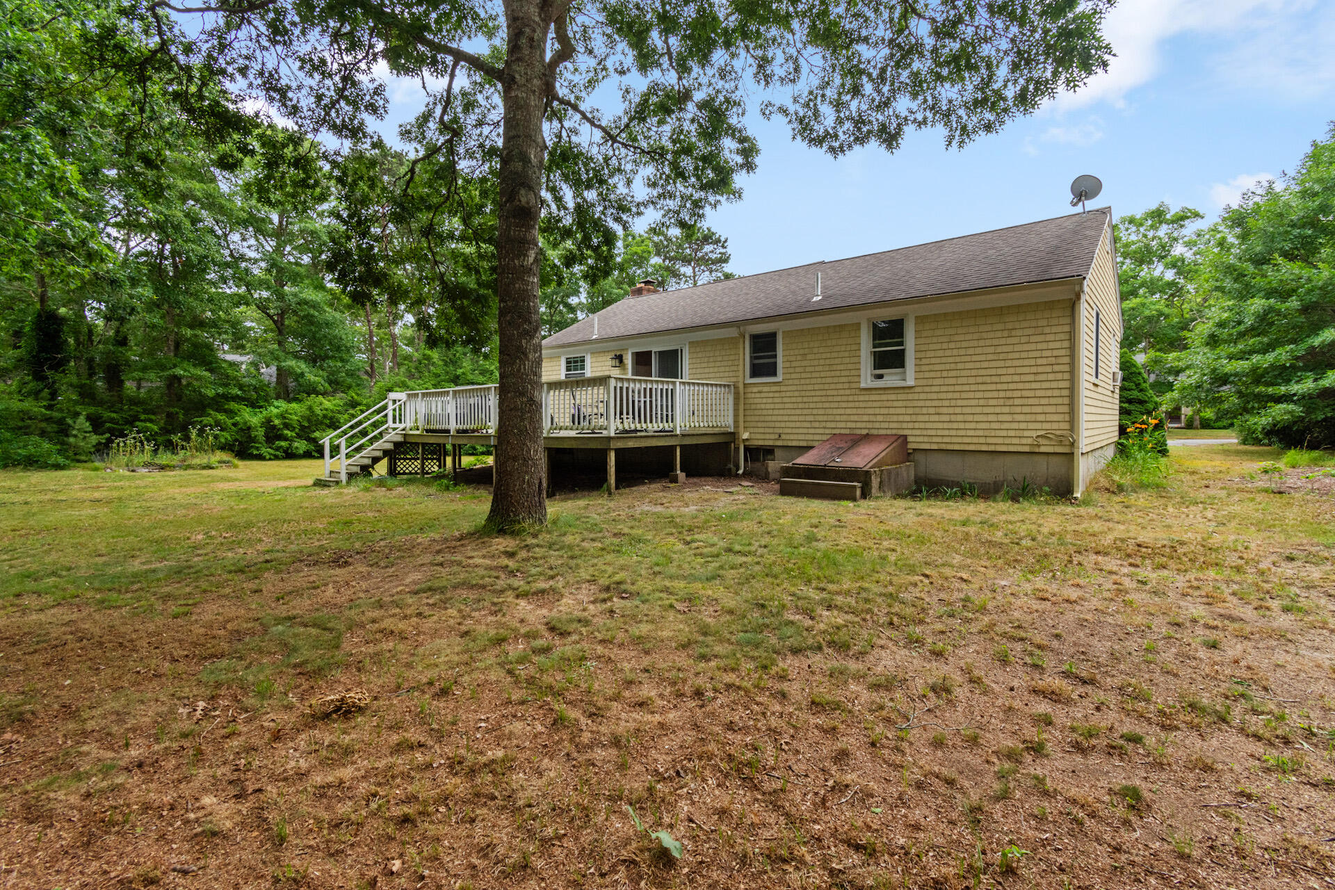 30 Patience Lane Cotuit, MA 02635 - Photo 24 of 27 a backyard of a house with barbeque oven and trees