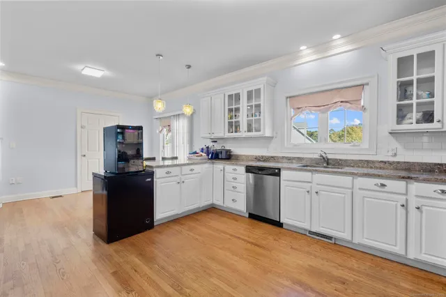 a kitchen with granite countertop a refrigerator stove top oven and sink