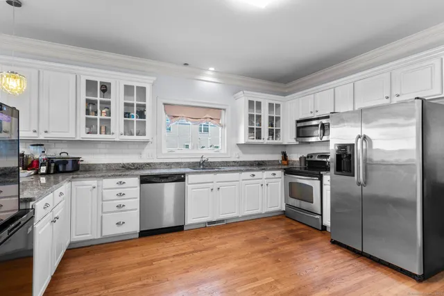 a kitchen with granite countertop stainless steel appliances a refrigerator sink and microwave
