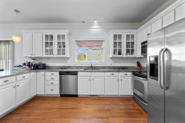a kitchen with stainless steel appliances granite countertop a stove sink and cabinets