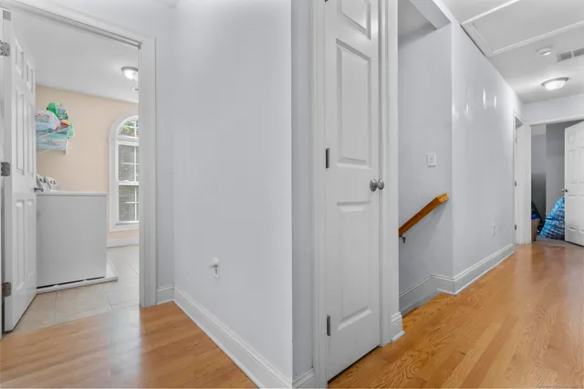 a view of a hallway with wooden floor and staircase