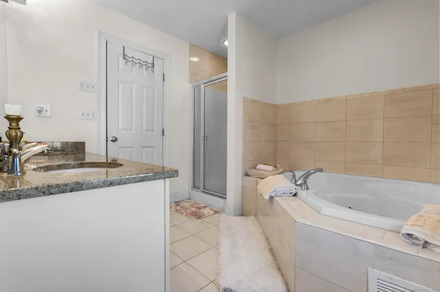 a bathroom with a granite countertop sink a toilet and bathtub