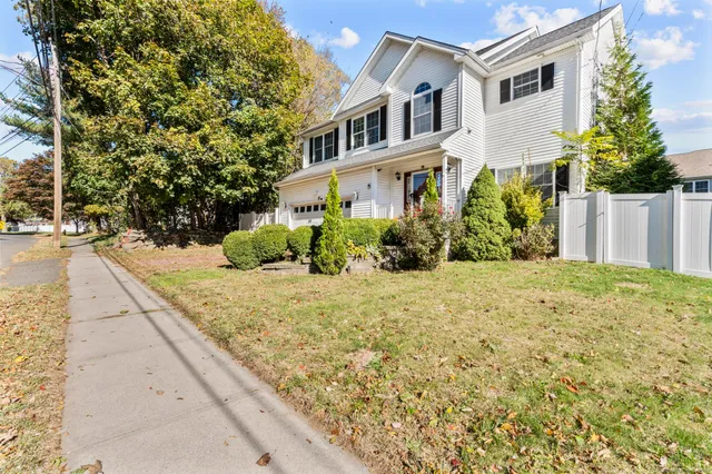 a view of a white house with a yard and plants