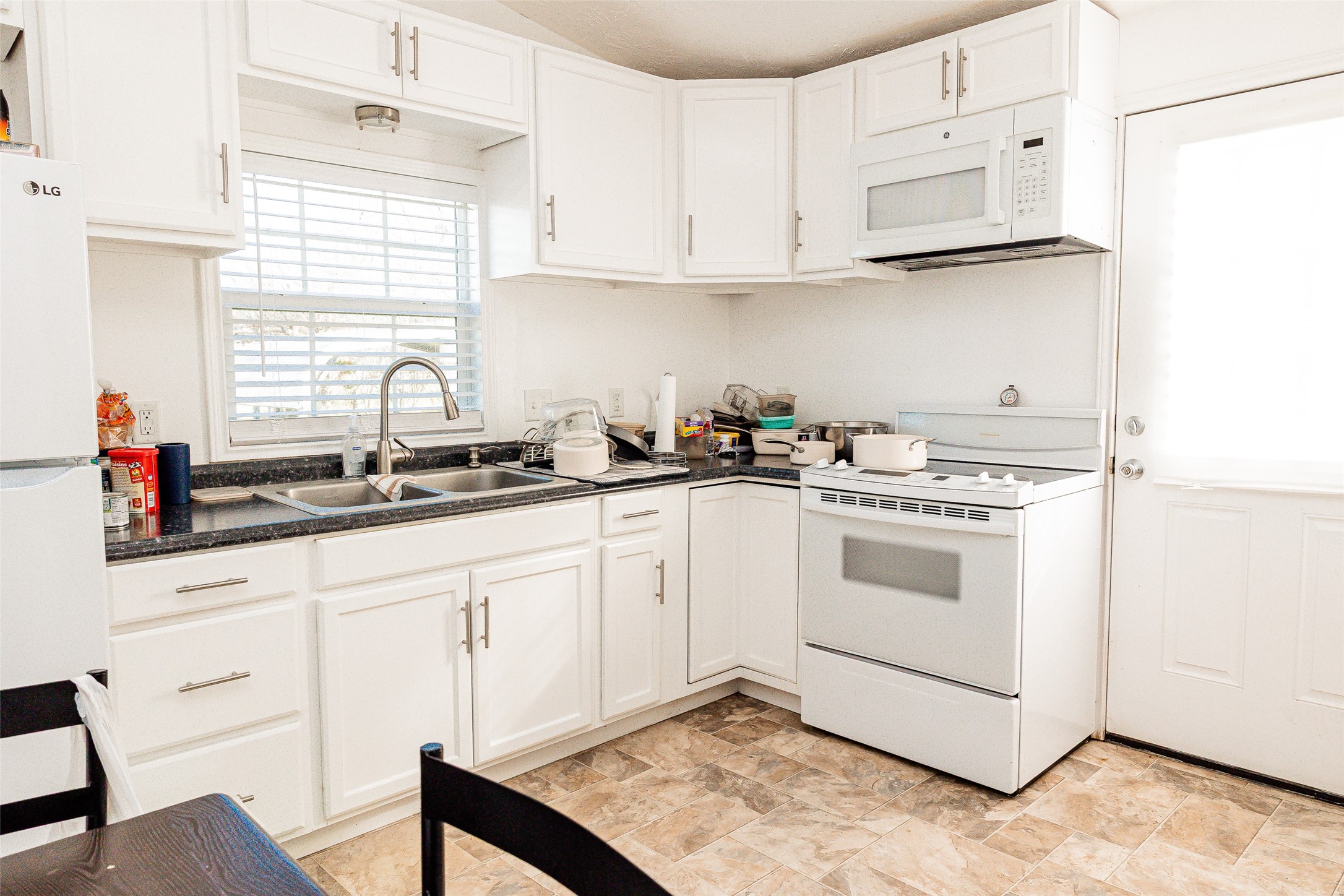 8608 Captain Scott Road Brenham, TX 77833 - Photo 23 of 28 a kitchen with white cabinets and white appliances