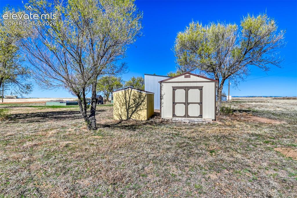 22558 Enoch Road Calhan, CO 80808 - Photo 25 of 50 a white house that has a tree in front of it